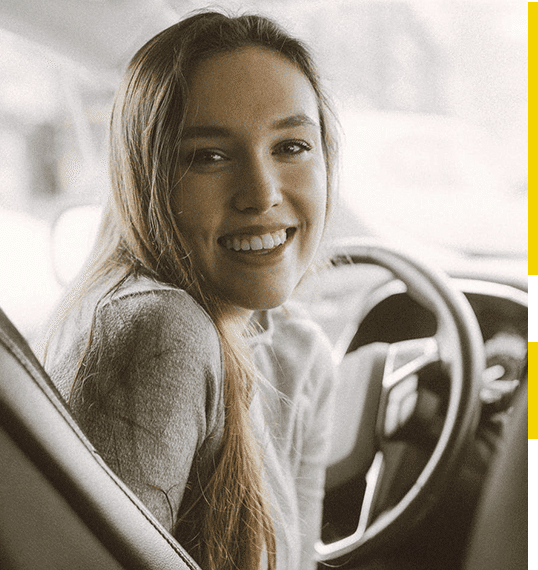 Mulher dentro do carro sorrindo